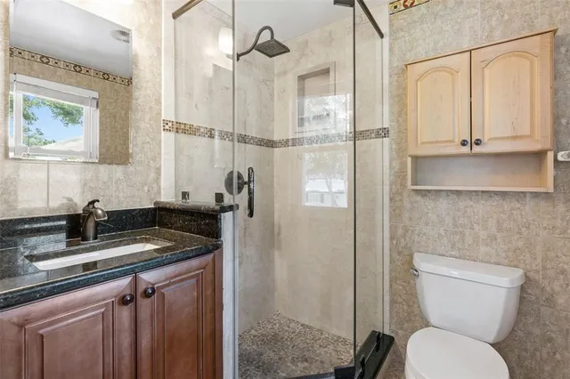 a bathroom with a granite countertop sink toilet and shower