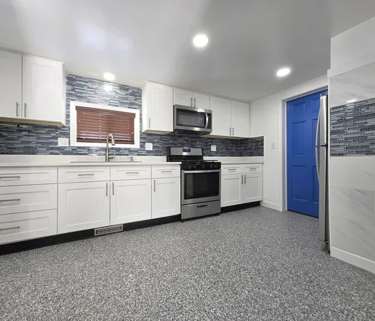 a kitchen with stainless steel appliances granite countertop a refrigerator sink and microwave