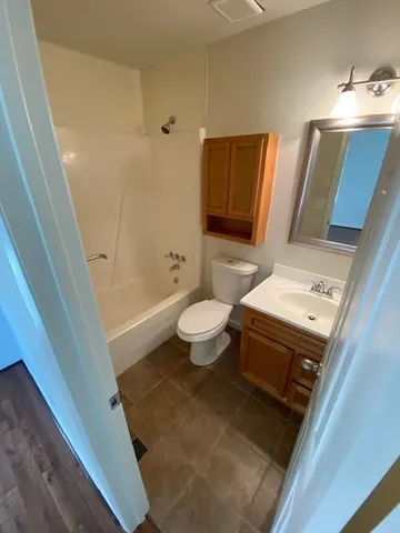 a bathroom with a sink a toilet a mirror and shower