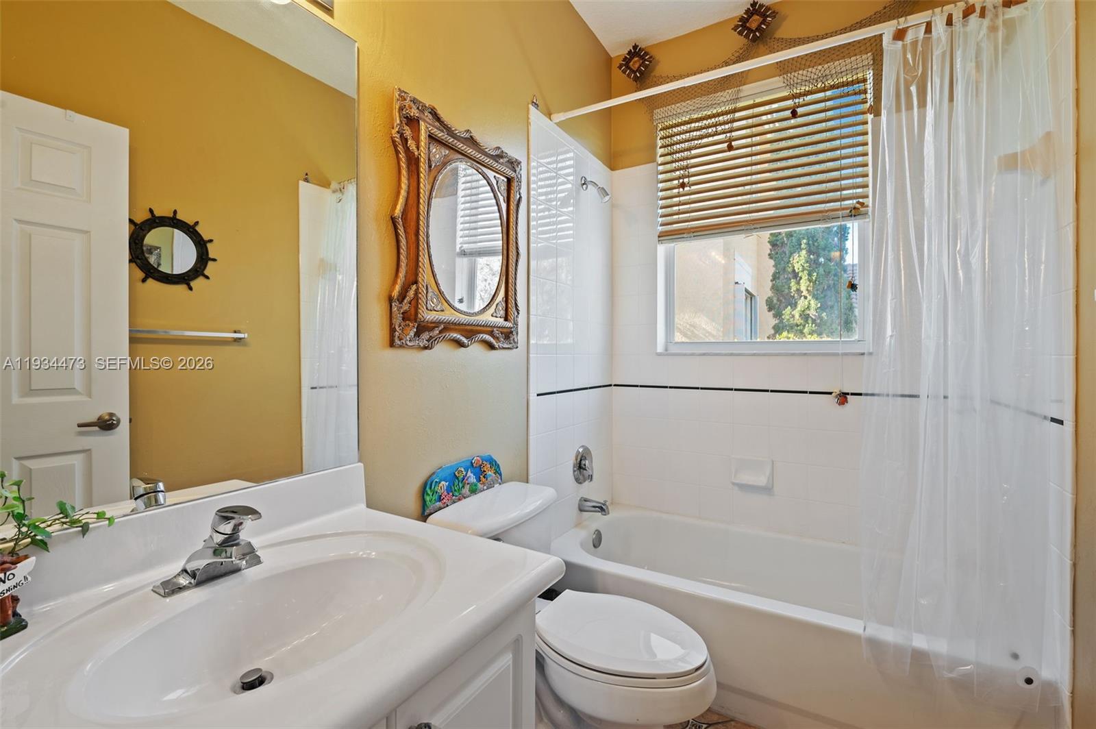 18900 Southwest 29th Street Miramar, FL 33029 - Photo 20 of 40 a bathroom with a sink a toilet a mirror a vanity and bathtub