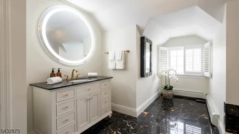 a en suite bathroom with a granite countertop double vanity sink and mirror