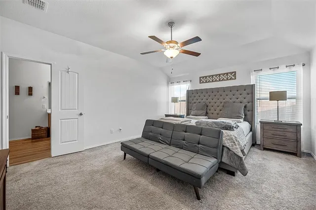 a bedroom with a bed a window and a flat screen television