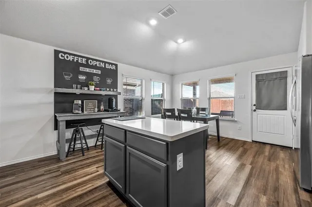 a kitchen with a cabinets a sink and a stove top oven with wooden floor