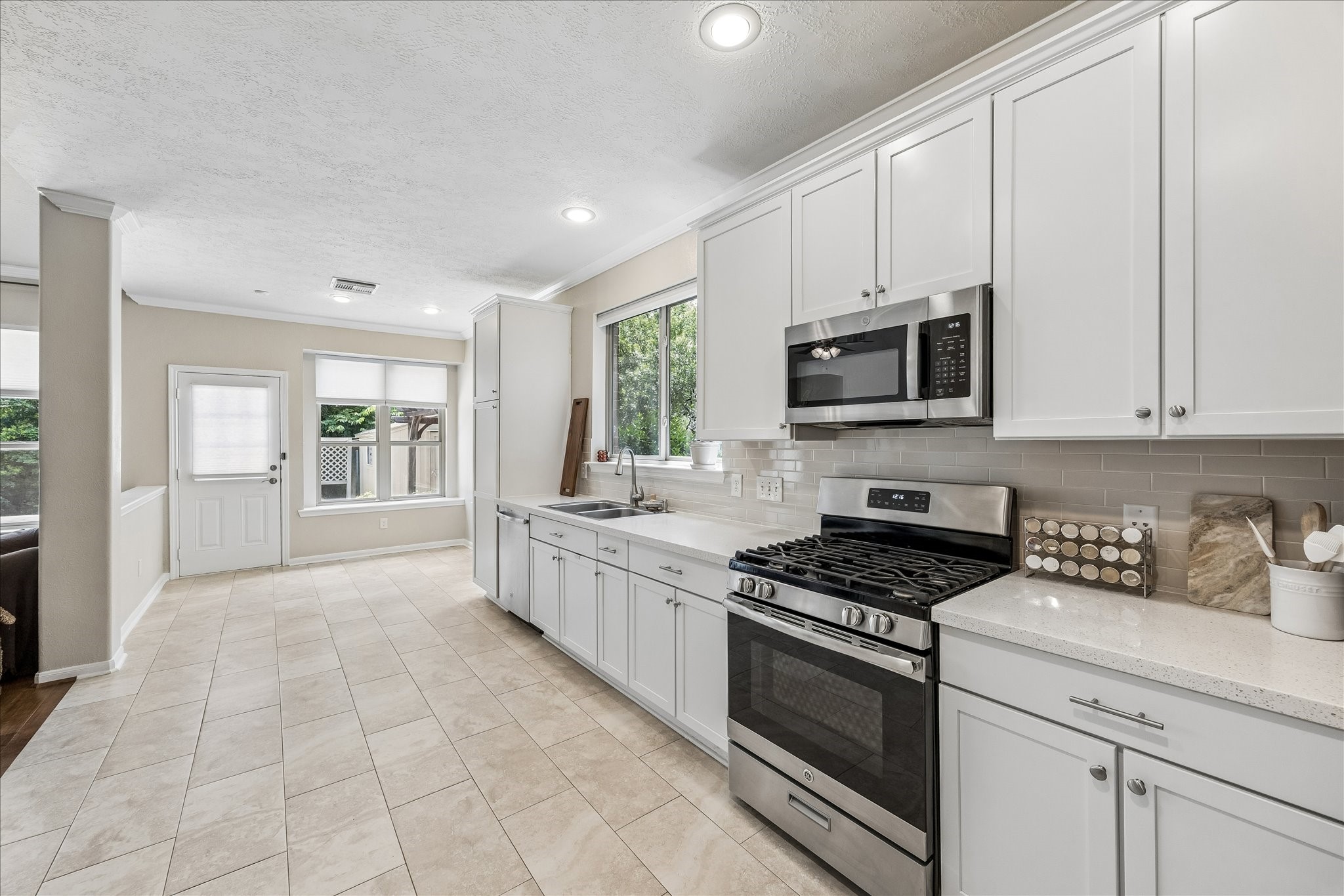 5811 Walkabout Way Katy, TX 77450 - Photo 7 of 33 Bright, updated kitchen featuring crisp white cabinetry, quartz-style countertops, stainless steal appliances, and abundant workspace.