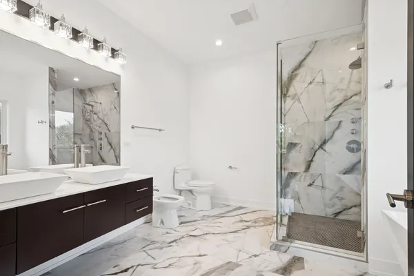 a spacious bathroom with a double vanity sink toilet and shower