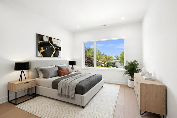 a bedroom with a large bed couch and a potted plant