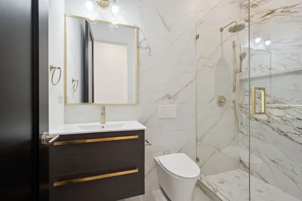 a bathroom with a sink a toilet and shower