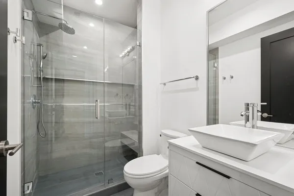 a bathroom with a sink a toilet and shower