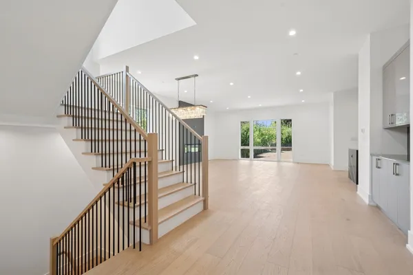 a view of a hallway with wooden floor and windows