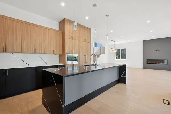 a large kitchen with kitchen island a sink stainless steel appliances and cabinets
