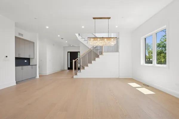 a view of empty room with a window and chandelier