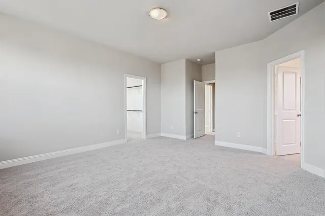 an empty room with closet and windows