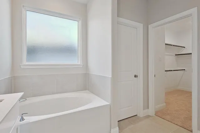 a white bath tub sitting next to a shower