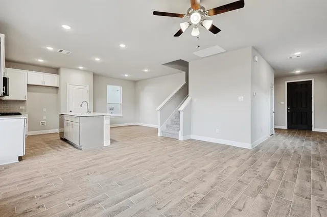 a view of an empty room and kitchen view