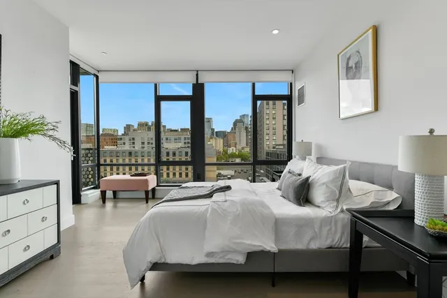 a bedroom with a bed and a large window