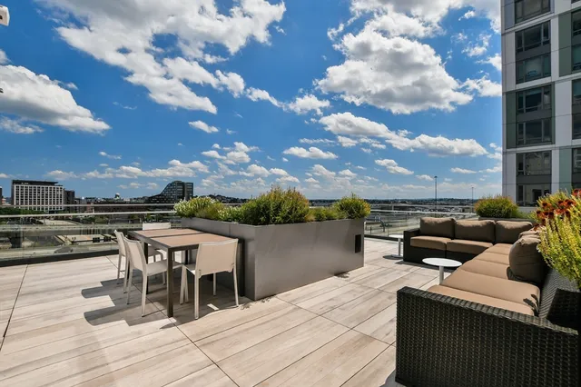 a roof deck with table and chairs