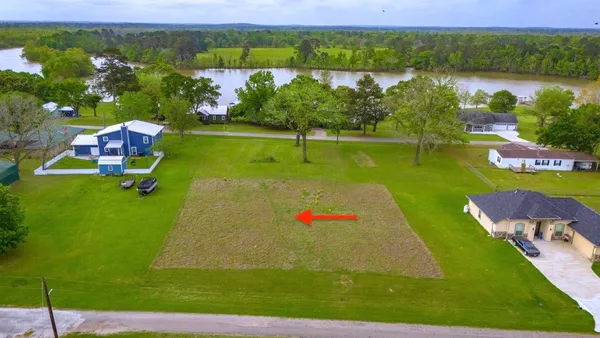 an aerial view of a house with a yard and lake view
