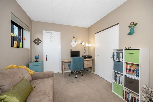 a living room with a book shelf and a wooden floor