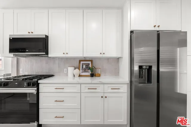 a kitchen with white cabinets and stainless steel appliances