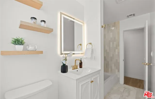 a bathroom with a sink a toilet and shower