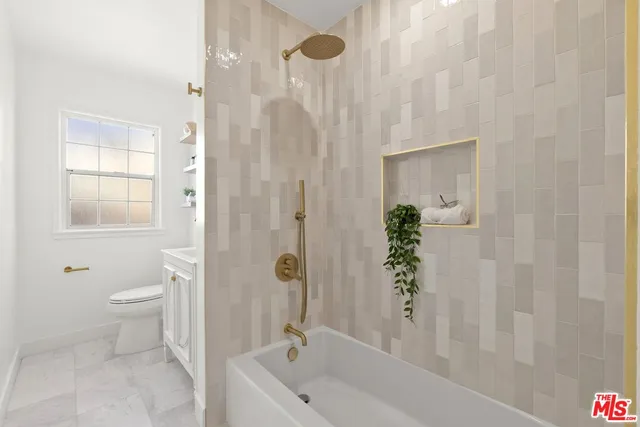 a bathroom with a granite countertop sink a toilet and shower