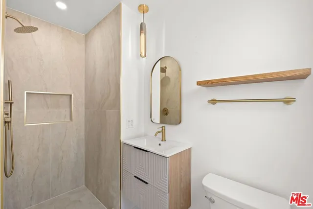 a bathroom with a sink a toilet and shower