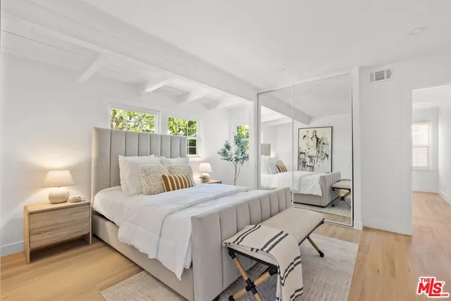 a bedroom with a bed and wooden floor