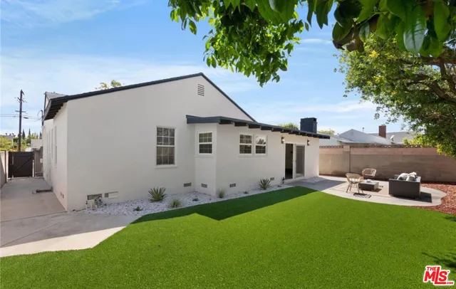 a backyard of a house with table and chairs