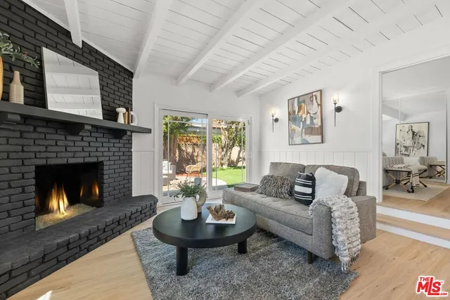 a living room with furniture a fireplace a lamp and a large window