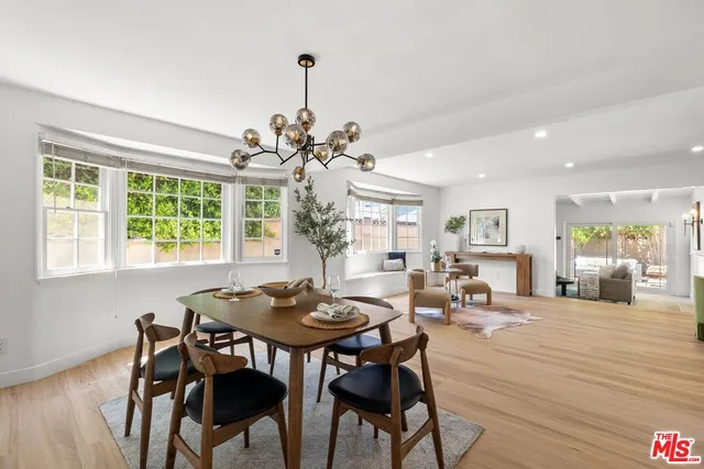 a view of a dining room and livingroom with furniture wooden floor a chandelier