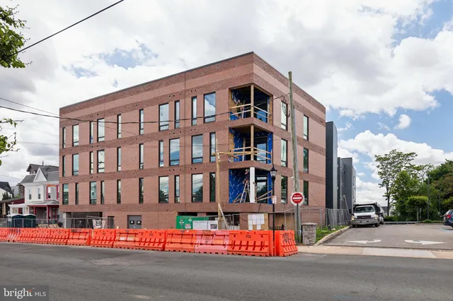 a city street lined with tall buildings and a yard