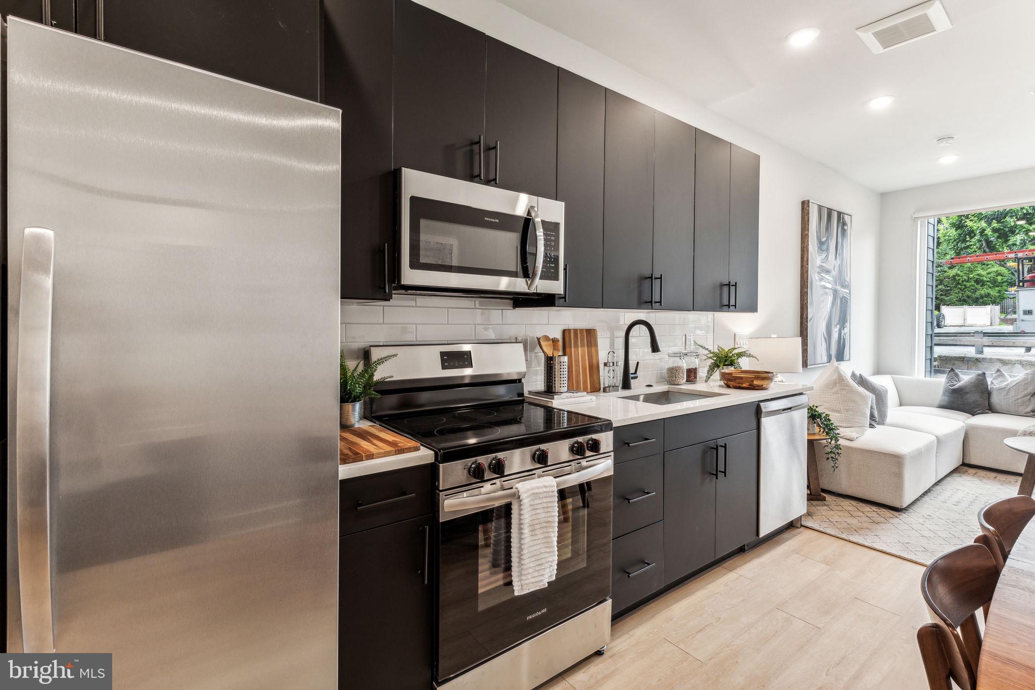 6910 Ridge Avenue, Unit 319 Philadelphia, PA 19128 - Photo 3 of 20 a kitchen with stainless steel appliances a stove a sink and a microwave