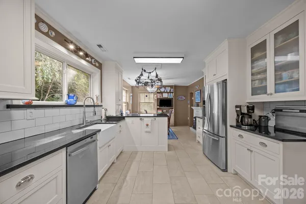 a kitchen with granite countertop stainless steel appliances a refrigerator and cabinets