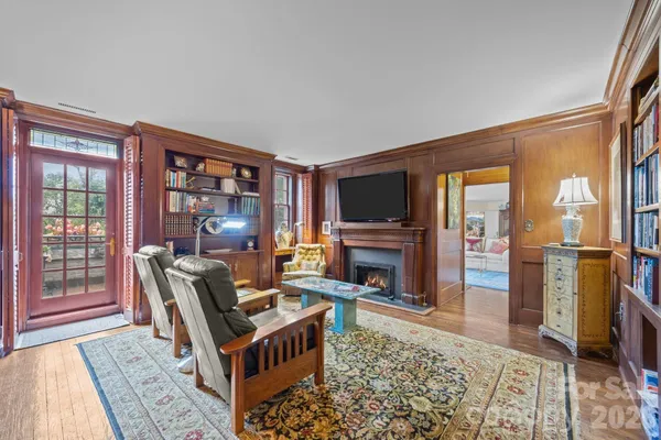 a living room with furniture a rug and a bookshelf