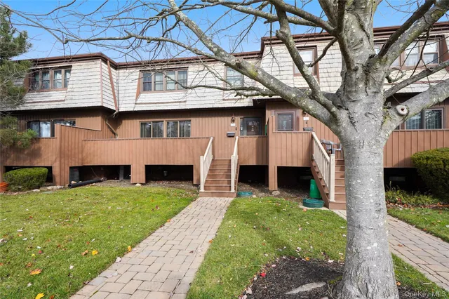 a view of a yard in front of a house with large tree