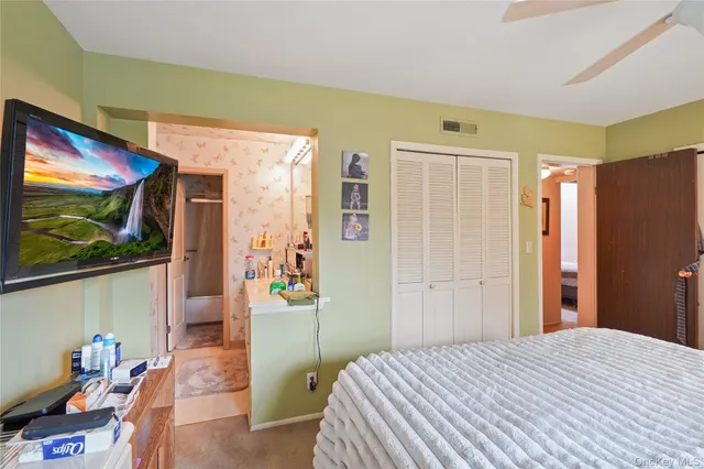 a bedroom with a bed and a large mirror on the dresser