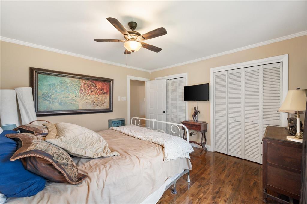 14036 Old Texaco Road Conroe, TX 77302 - Photo 15 of 40 Bedroom with wood finished floors, multiple closets, baseboards, ceiling fan, and ornamental molding
