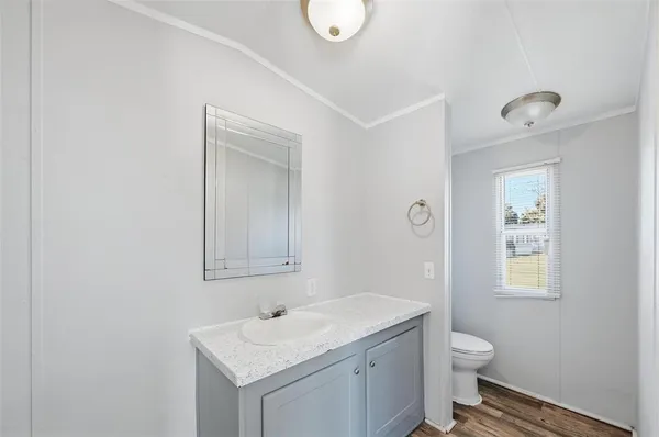 a bathroom with a toilet sink vanity and mirror