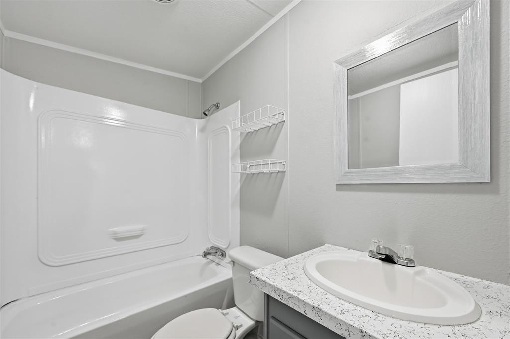 607 Keats Road Wilmer, TX 75172 - Photo 19 of 27 a bathroom with a granite countertop sink toilet and shower