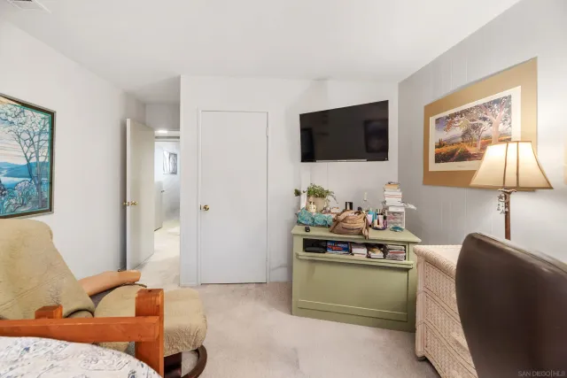 a bedroom with a bed and a refrigerator