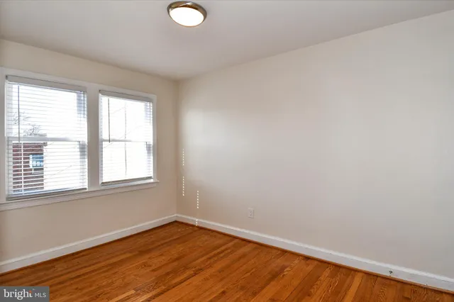 a view of a room with wooden floor and windows
