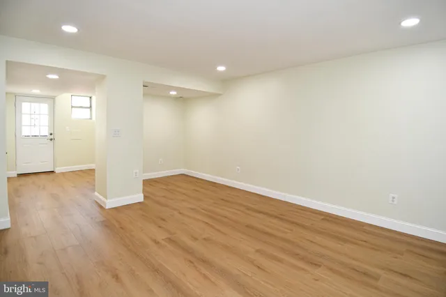 a view of a hallway with wooden floor and closet area