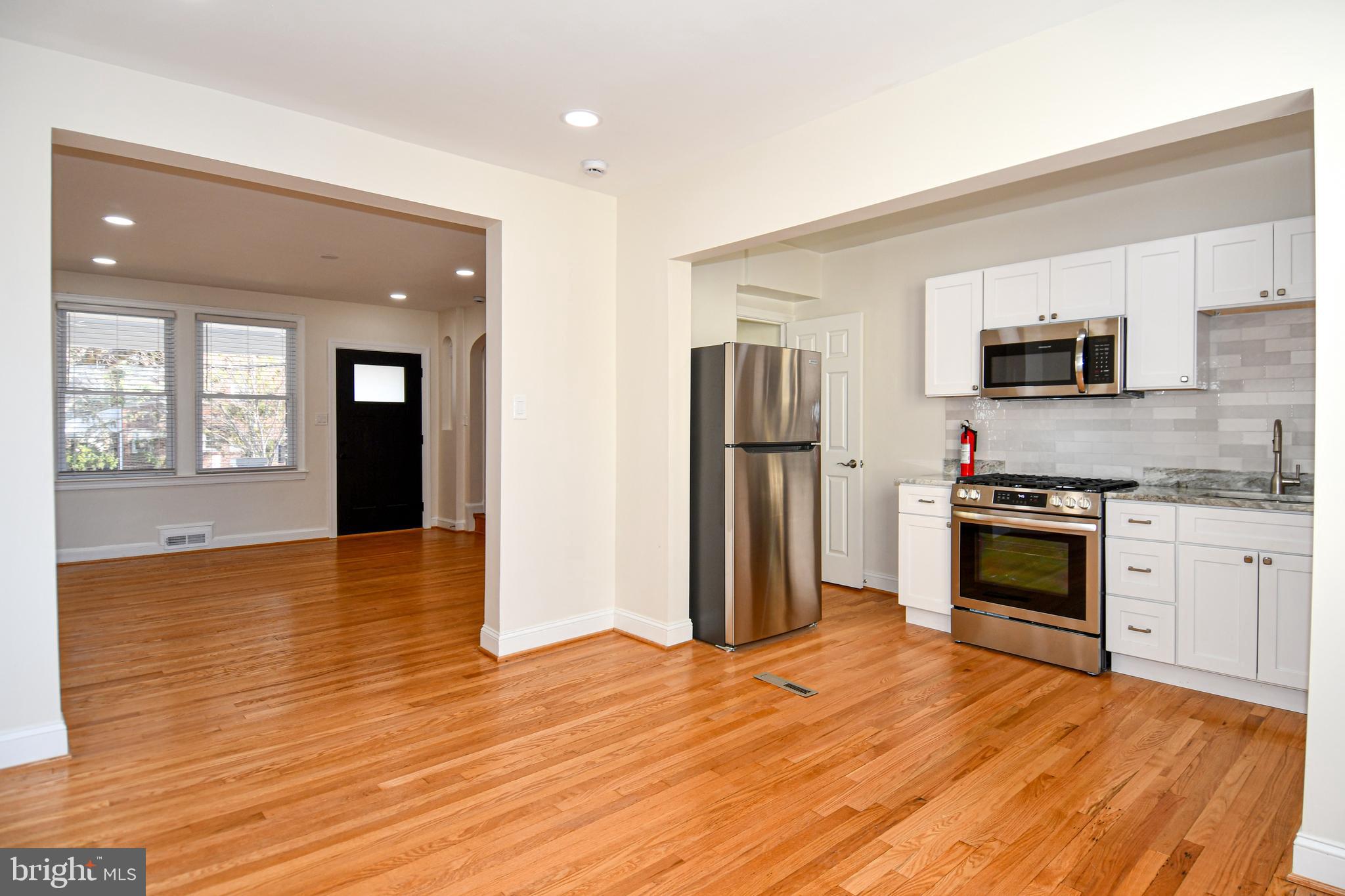 4620 Sargent Road Northeast Washington, DC 20017 - Photo 6 of 34 a kitchen with granite countertop a stove and a refrigerator
