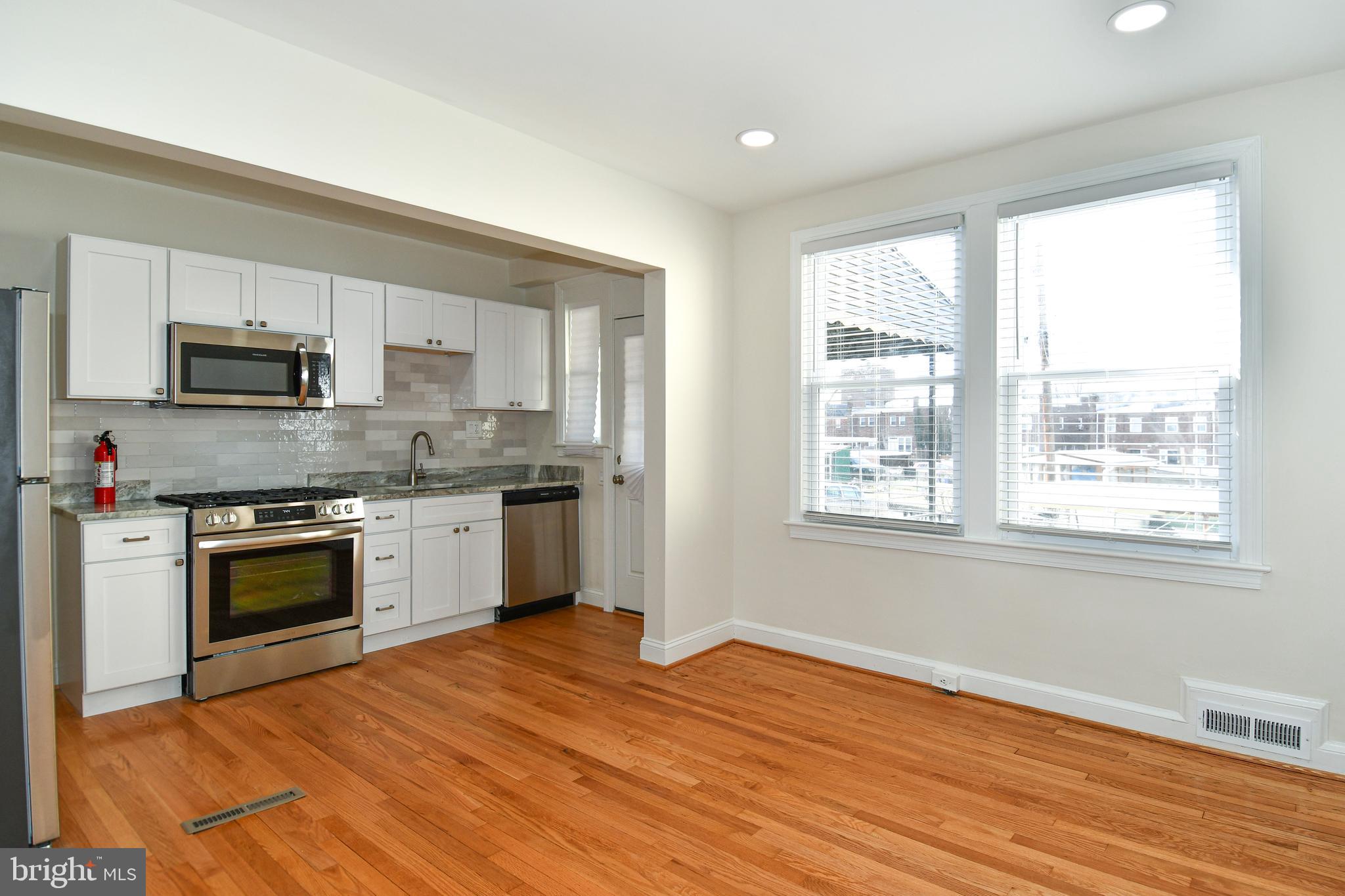 4620 Sargent Road Northeast Washington, DC 20017 - Photo 9 of 34 a kitchen with stainless steel appliances granite countertop a stove a sink and a microwave