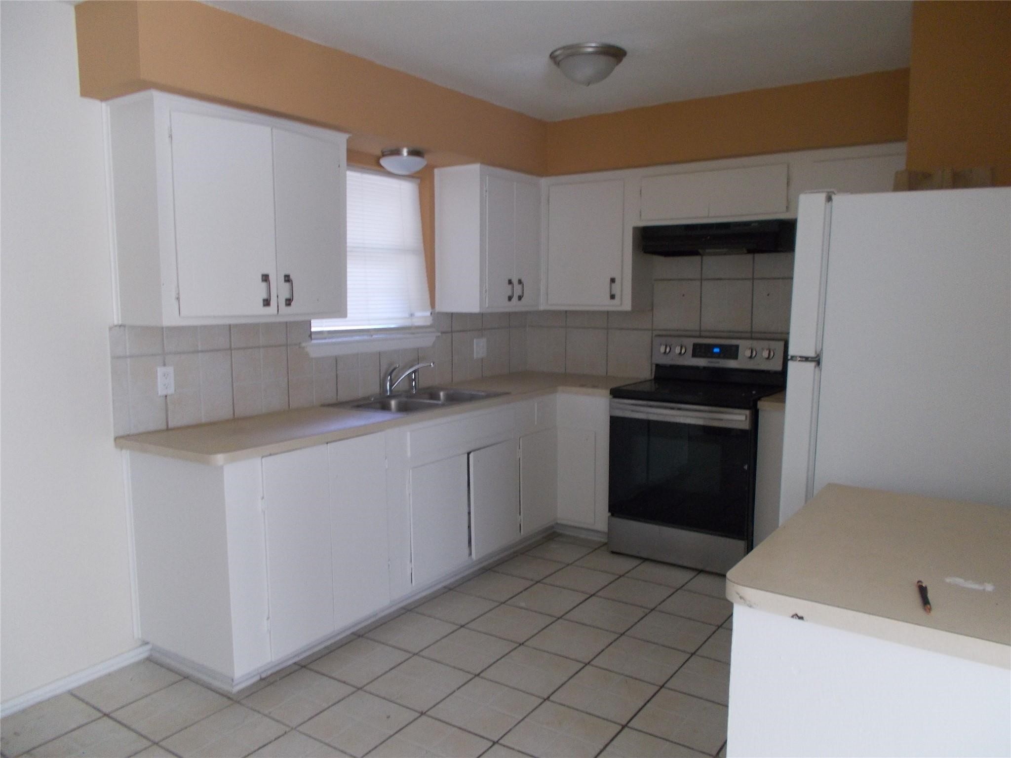 1923 Ojeman Road Houston, TX 77080 - Photo 12 of 14 a kitchen with a sink stove and cabinets