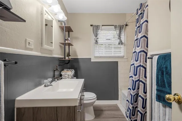 a bathroom with a sink a toilet and a window