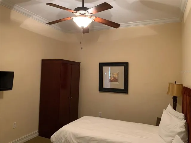 a bedroom with a bed and a ceiling fan