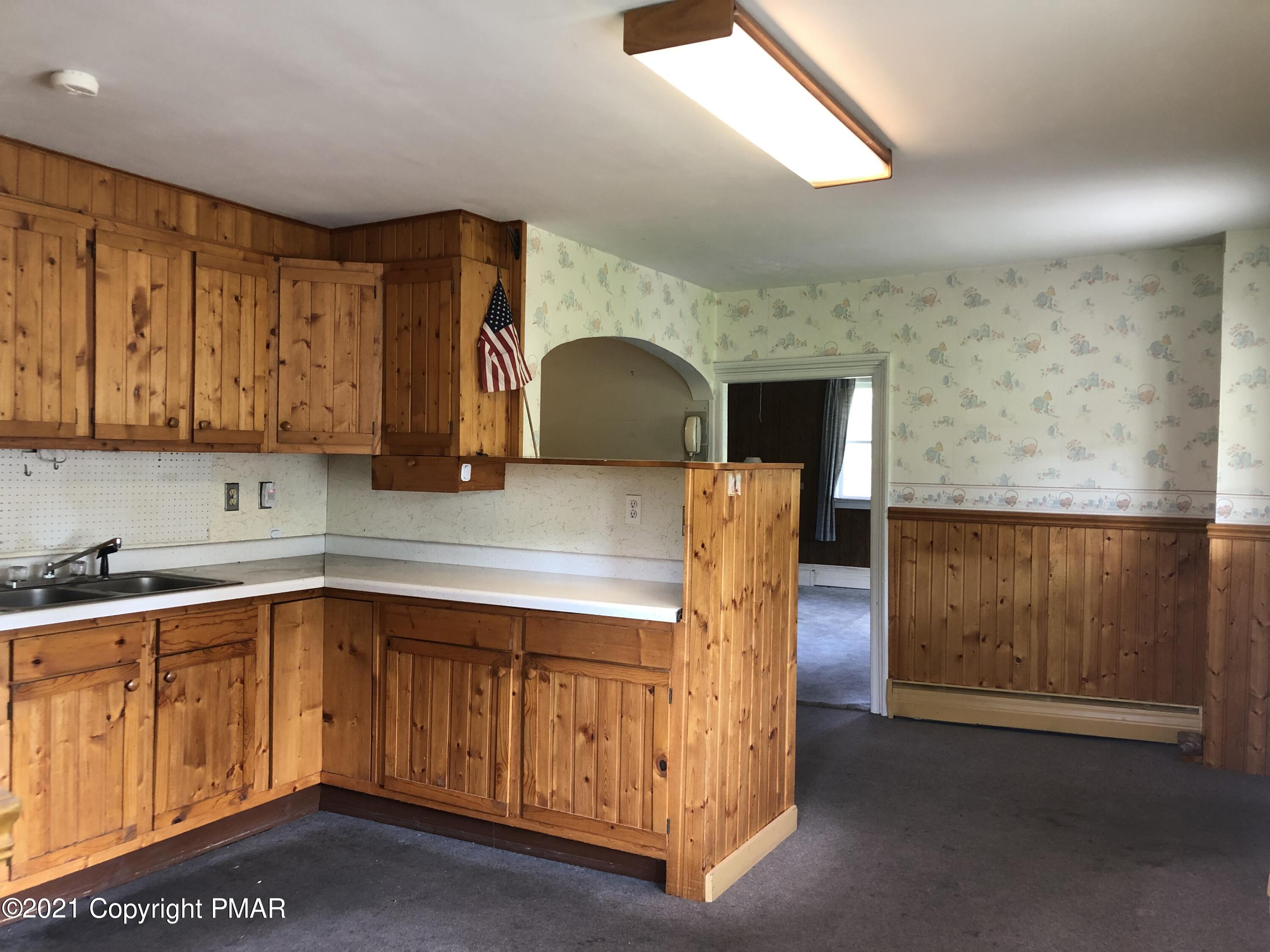 173 Anchorage Road Saylorsburg, PA 18353 - Photo 22 of 56 a kitchen with a sink a stove and cabinets