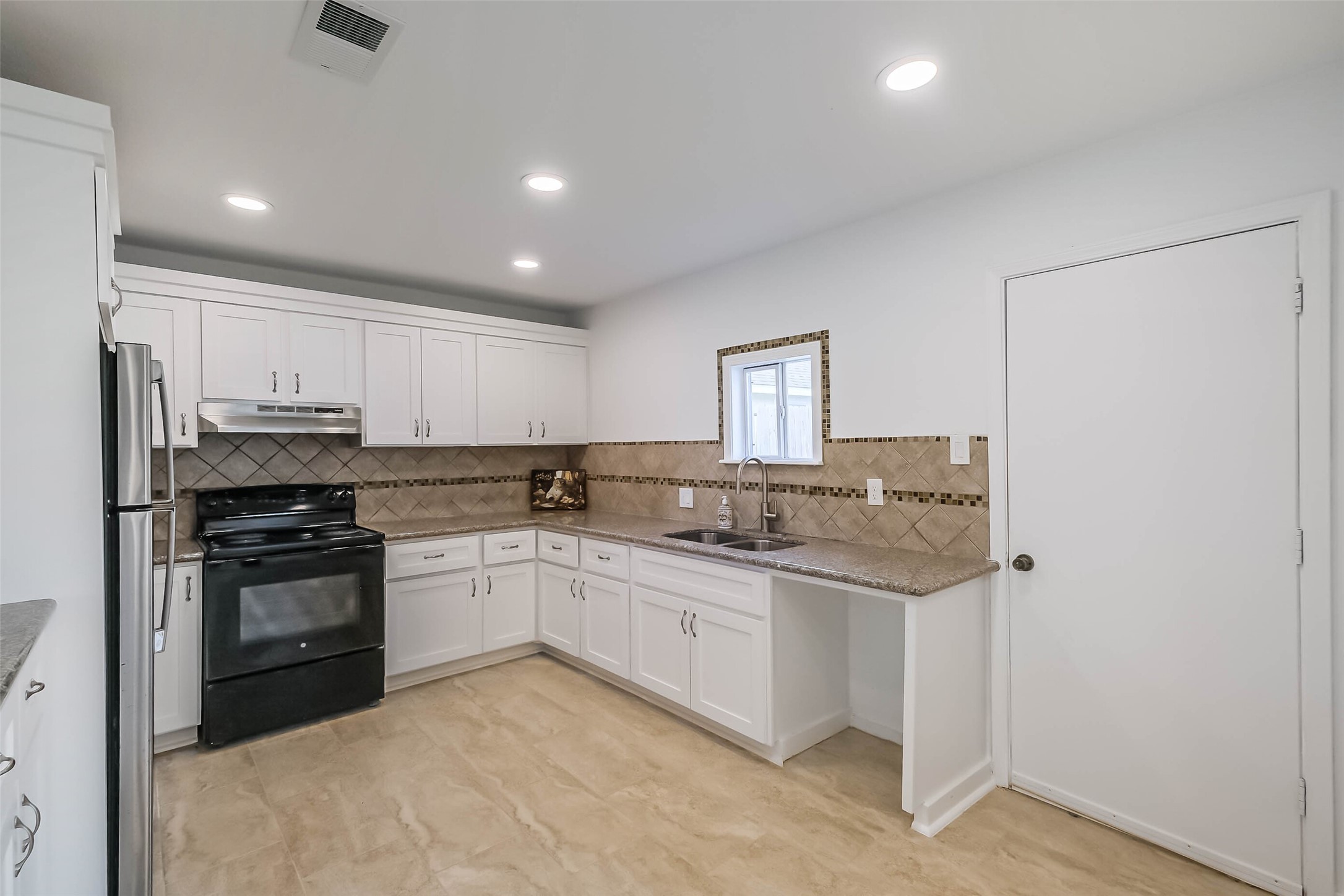 7543 Greenstone Street Houston, TX 77087 - Photo 6 of 24 a kitchen with stainless steel appliances granite countertop a sink and cabinets