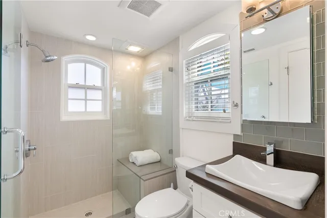 a bathroom with a toilet a sink and glass door